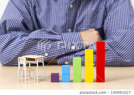A man troubled by building block graphs and education costs. A man troubled by building block graphs and education costs. 140991027