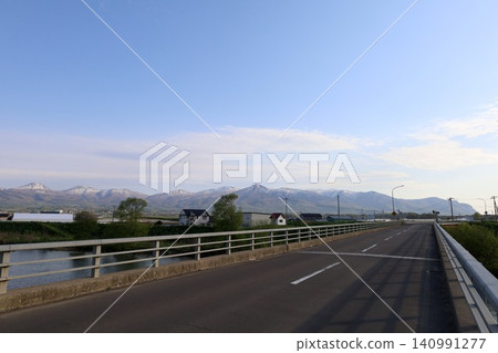 北海道的春天,黃昏時分,從尻別市積丹半島底部的協和町堀部川附近眺望二世古山脈和雷電海岸。 北海道的春天,黃昏時分,從尻別市積丹半島底部的協和町堀部川附近眺望二世古山脈和雷電海岸。 140991277