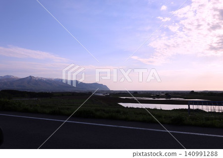 北海道的春天,黃昏時分,從尻別市積丹半島底部的協和町堀部川附近眺望二世古山脈和雷電海岸。 北海道的春天,黃昏時分,從尻別市積丹半島底部的協和町堀部川附近眺望二世古山脈和雷電海岸。 140991288