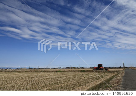 A rural landscape in Kuki City, Saitama Prefecture, with a large tractor parked nearby. 140991630