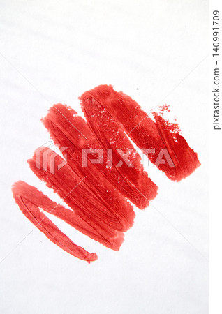 Close-up of a red lipstick smear on a white background Close-up of a red lipstick smear on a white background 140991709