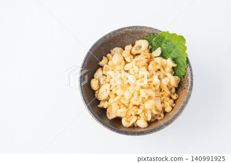 Tempura batter scraps and shiso leaves served on a small plate Tempura batter scraps and shiso leaves served on a small plate 140991925