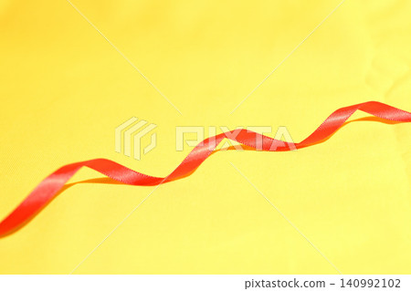 Red ribbon on a yellow background Red ribbon on a yellow background 140992102