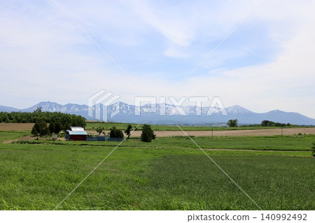 六月的北海道，春天的北海道，初夏的北海道：從美瑛市西北丘陵展望公園眺望美瑛市和十勝山脈，美瑛市是一個丘陵起伏的小鎮。 140992492