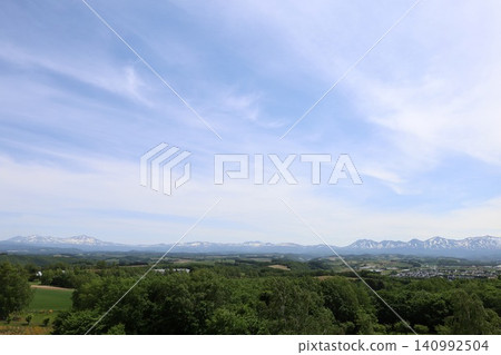 六月的北海道，春天的北海道，初夏的北海道：從美瑛市西北丘陵展望公園眺望美瑛市和十勝山脈，美瑛市是一個丘陵起伏的小鎮。 140992504