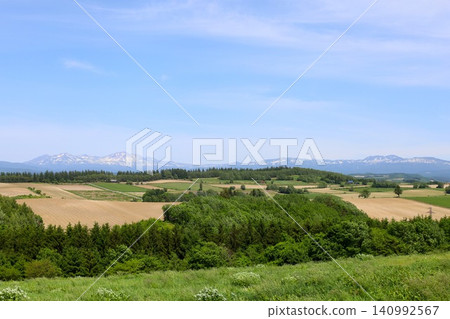 六月的北海道，春天的北海道，初夏的北海道：從美瑛市西北丘陵展望公園眺望美瑛市和十勝山脈，美瑛市是一個丘陵起伏的小鎮。 140992567