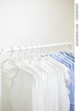 A hanger rack filled with tops in refreshing white and blue colors. A hanger rack filled with tops in refreshing white and blue colors. 140992669