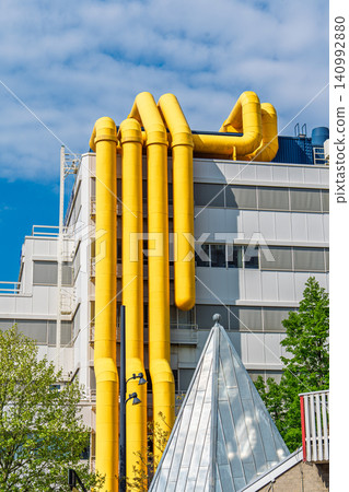 Modern office building with yellow ventilation pipes on the exterior facade in Rotterdam city Modern office building with yellow ventilation pipes on the exterior facade in Rotterdam city 140992880
