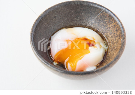 Onsen tamago (soft-boiled egg) with the yolk broken and soy sauce poured over it. Onsen tamago (soft-boiled egg) with the yolk broken and soy sauce poured over it. 140993338