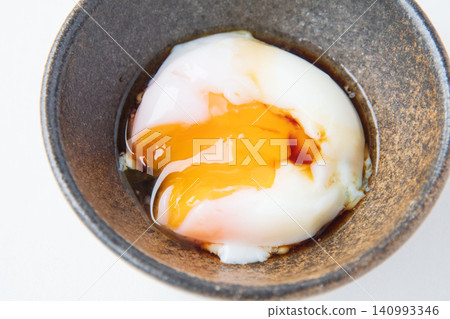 Onsen tamago (soft-boiled egg) with the yolk broken and soy sauce poured over it. Onsen tamago (soft-boiled egg) with the yolk broken and soy sauce poured over it. 140993346