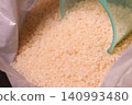 White rice in a rice bag and a measuring cup 140993480