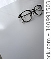 Glasses left behind on the desk 140993503