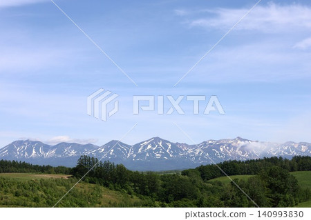 六月的北海道,春天的北海道,初夏的北海道:從美瑛市西北丘陵展望公園眺望美瑛市和十勝山脈,美瑛市是一個丘陵起伏的小鎮。 六月的北海道,春天的北海道,初夏的北海道:從美瑛市西北丘陵展望公園眺望美瑛市和十勝山脈,美瑛市是一個丘陵起伏的小鎮。 140993830