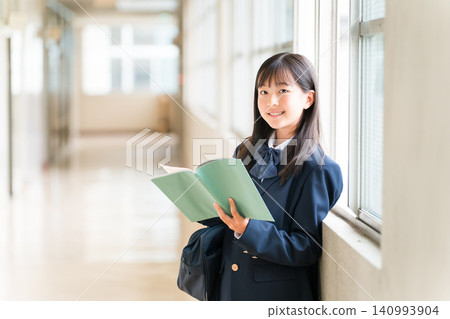 Elementary school, junior high school, and high school girls holding books in school corridors Elementary school, junior high school, and high school girls holding books in school corridors 140993904