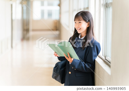 Elementary school, junior high school, and high school girls holding books in school corridors Elementary school, junior high school, and high school girls holding books in school corridors 140993905