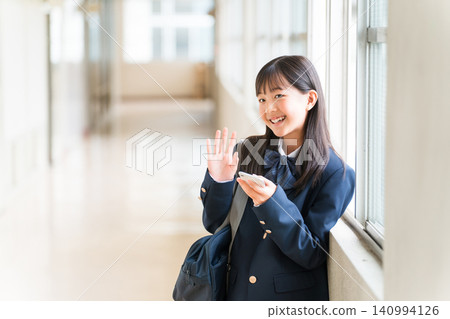 Junior high school students, high school students, elementary school students, female junior high school students, female high school students in uniform waving in the school hallway Junior high school students, high school students, elementary school students, female junior high school students, female high school students in uniform waving in the school hallway 140994126
