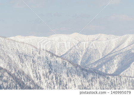 Shadows of snow-covered ridges and winter valleys Shadows of snow-covered ridges and winter valleys 140995079