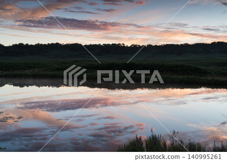 Sunrise clouds reflected in a marsh pond Sunrise clouds reflected in a marsh pond 140995261