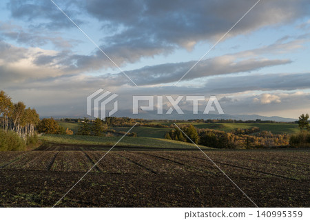 Cultivated black earth and autumn hills Cultivated black earth and autumn hills 140995359