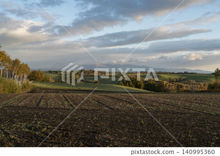 Cultivated black earth and autumn hills Cultivated black earth and autumn hills 140995360