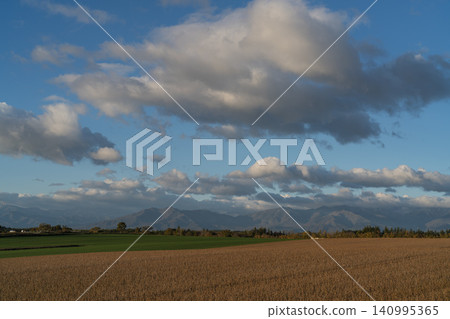 Golden wheat fields, majestic clouds, and mountain ranges. Golden wheat fields, majestic clouds, and mountain ranges. 140995365