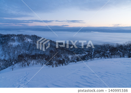 A sea of clouds in the blue hour and a winter valley. A sea of clouds in the blue hour and a winter valley. 140995386