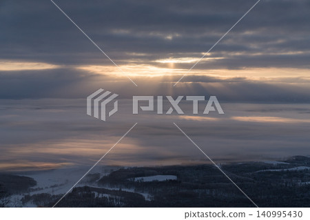 Dramatic rays of light shining through the misty valley 140995430