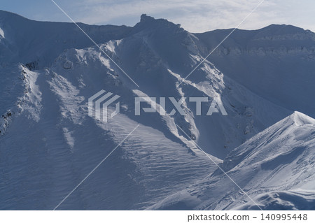 Snow-covered volcanic ridges and rugged rock faces Snow-covered volcanic ridges and rugged rock faces 140995448