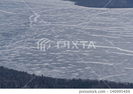 Cracks in a frozen caldera lake Cracks in a frozen caldera lake 140995489