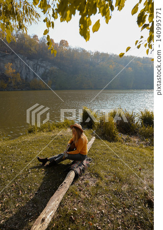 Blonde woman playing string guitar outdoors in autumn forest. Concept of sound therapy, mental health and wellness rituals. Calmness tranquility audio-sensory practices. Aura farming energy Blonde woman playing string guitar outdoors in autumn forest. Concept of sound therapy, mental health and wellness rituals. Calmness tranquility audio-sensory practices. Aura farming energy 140995771