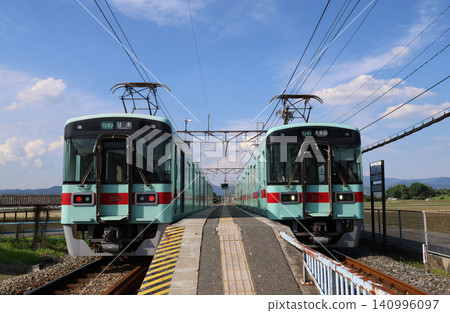 Nishitetsu Amagi Line 7000 series trains passing each other at Hongō Station. Nishitetsu Amagi Line 7000 series trains passing each other at Hongō Station. 140996097