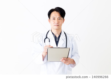 A middle-aged male doctor in a white coat holding a binder containing patient charts. A middle-aged male doctor in a white coat holding a binder containing patient charts. 140996266