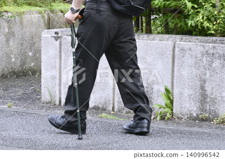 In a cityscape of Yokohama, Japan, an elderly man with a cane appears to have a tilted right ankle... In a cityscape of Yokohama, Japan, an elderly man with a cane appears to have a tilted right ankle... 140996542