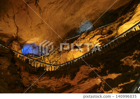Winding stone staircase in a huge Yellow Dragon Cave in the mountains near Zhangjiajie, China Winding stone staircase in a huge Yellow Dragon Cave in the mountains near Zhangjiajie, China 140996835