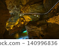 Underground river, and bridge illuminated by light in Yellow Dragon Cave near Zhangjiajie, China 140996836