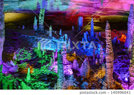 Stalactites and stalagmites colored by light in the huge Yellow Dragon Cave near Zhangjiajie, China 140996841