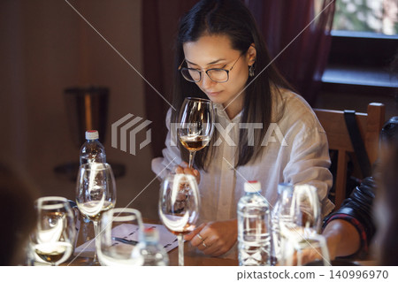 Sommelier in Training: Woman Examining Wine at Tasting Event Sommelier in Training: Woman Examining Wine at Tasting Event 140996970