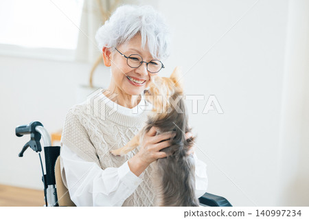 Elderly care: Senior woman relaxing with her pet dog. Elderly care: Senior woman relaxing with her pet dog. 140997234