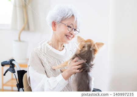 Elderly care: Senior woman relaxing with her pet dog. Elderly care: Senior woman relaxing with her pet dog. 140997235
