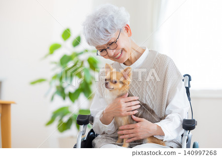 老年護理:一位老婦人與她的寵物狗一起放鬆。 老年護理:一位老婦人與她的寵物狗一起放鬆。 140997268