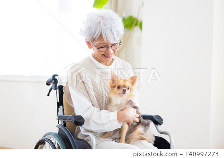 Elderly care: Senior woman relaxing with her pet dog. Elderly care: Senior woman relaxing with her pet dog. 140997273