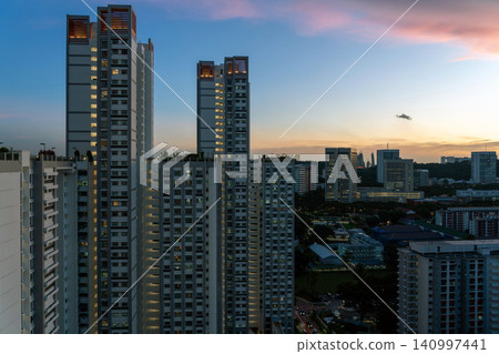 The streets of Singapore's high-rise public housing (HDB) buildings bathed in the golden light of dusk. 140997441