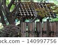A gazebo in a Japanese garden made of bamboo, surrounded by greenery. 140997756