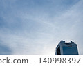 A refreshing background image featuring city skyscrapers and a clear blue sky with soft clouds. 140998397