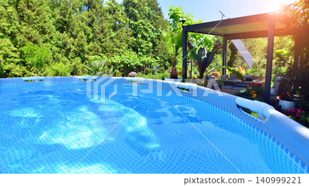 Outdoor swimming pool in a garden with lawn, plants and trees. Outdoor swimming pool in a garden with lawn, plants and trees. 140999221