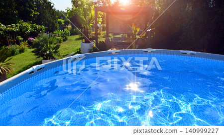 Outdoor swimming pool in a garden with lawn, plants and trees. Outdoor swimming pool in a garden with lawn, plants and trees. 140999227