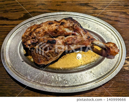 A fragrant, grilled bone-in chicken served on a silver plate, a specialty of Kagawa Prefecture, with its delicious juices. A fragrant, grilled bone-in chicken served on a silver plate, a specialty of Kagawa Prefecture, with its delicious juices. 140999666