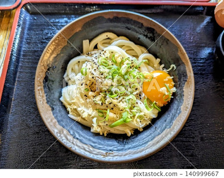 Sanuki Kamatama Udon with raw egg, green onions, and tempura flakes as toppings. 140999667