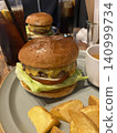A lunch plate featuring a juicy cheeseburger. 140999734