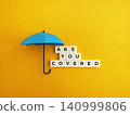 Umbrella protecting letter tiles spelling are you covered 140999806